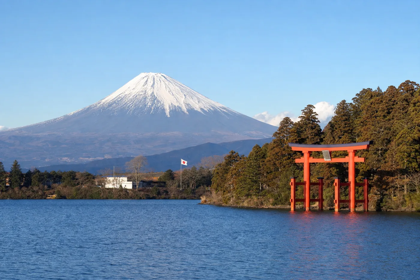 Mount Fuji seen across a lake with a red torii gate, Japan